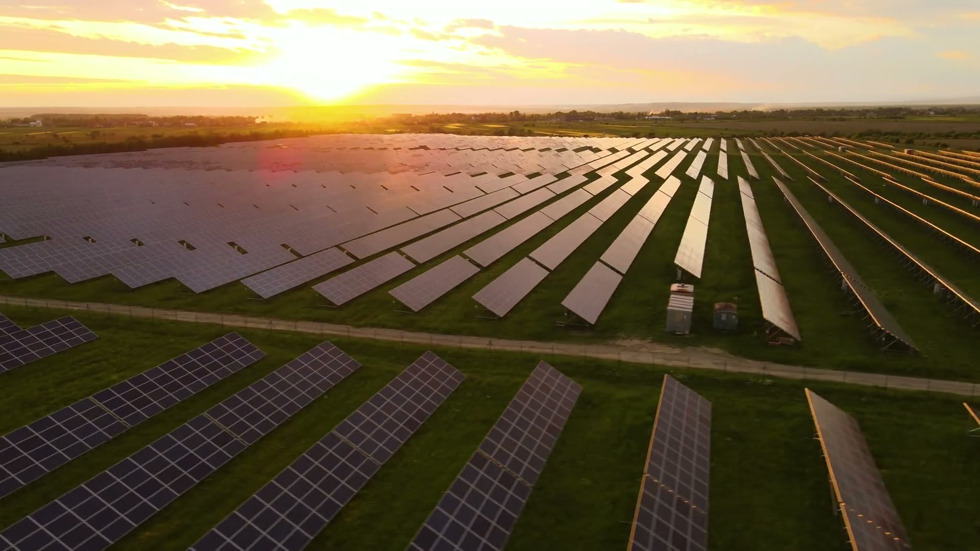 Solar installation extending across open land at sunset
